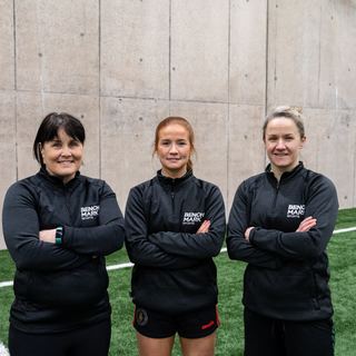 Three Benchmark coaches on an indoor pitch
